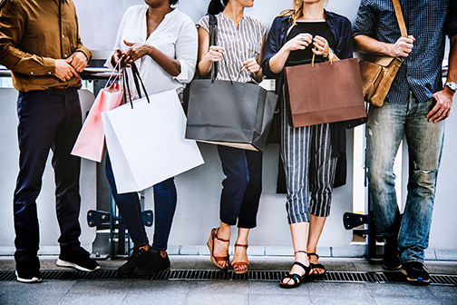 friends shopping together against a wall